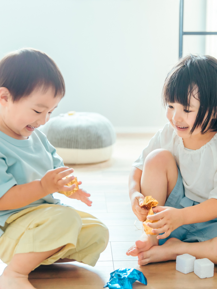 座って遊んでいる二人の子供